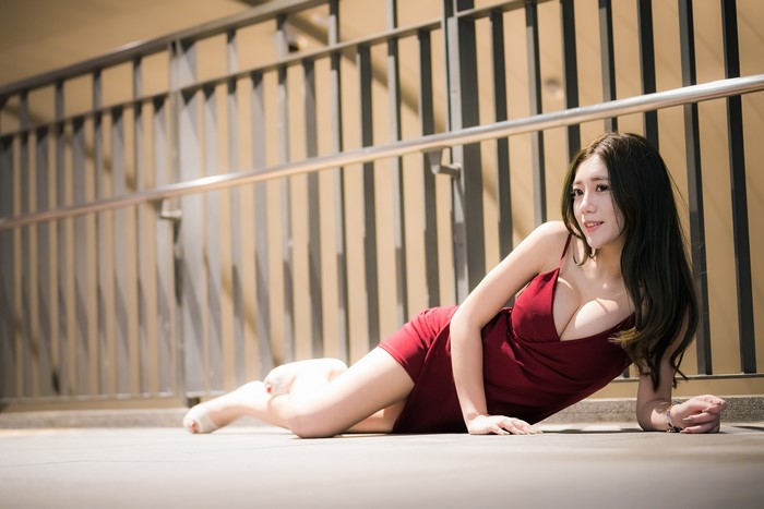 Asian woman in red dress lying down
