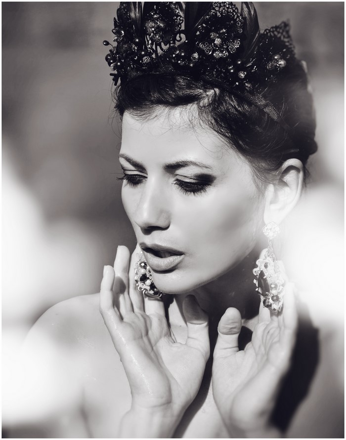Black and white portrait of a woman with a crown and earrings