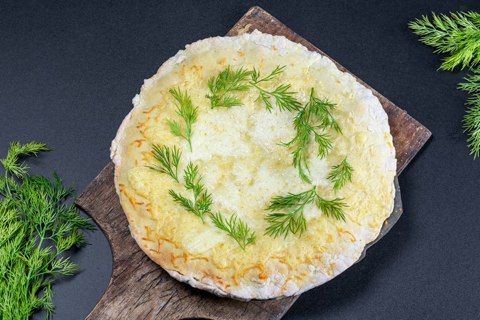 4K cheese pie with dill on cutting board