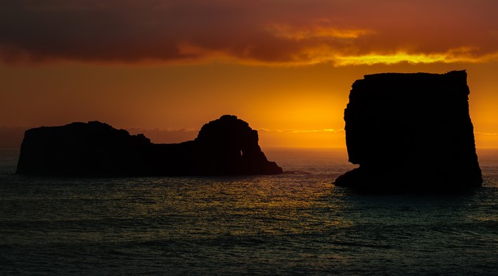 Silhouette of rock formations at Dyrholaey, Iceland during sunset