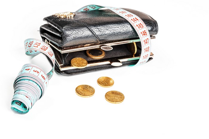 Black wallet with coins and measuring tape