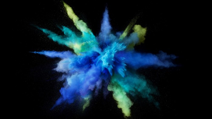 Blue and green powder explosion on black background