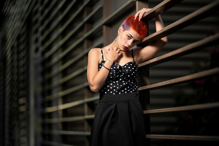 Woman with short red and purple hair in polka dot top