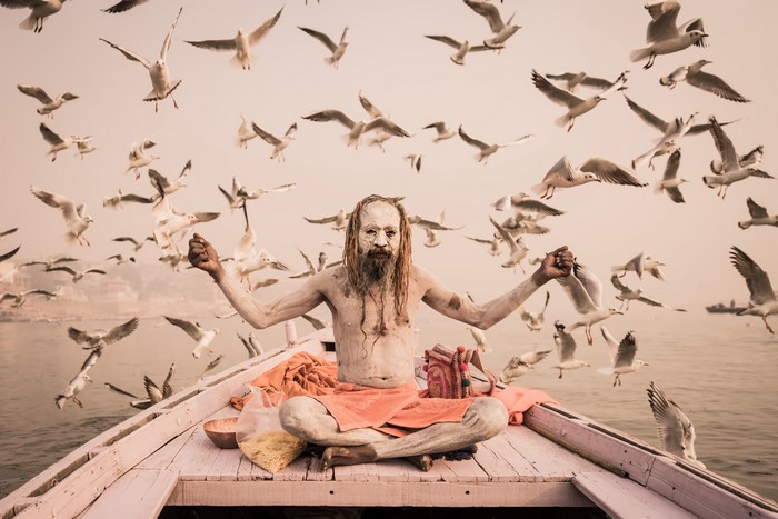 Man in Lotus Position on Boat with Seagulls