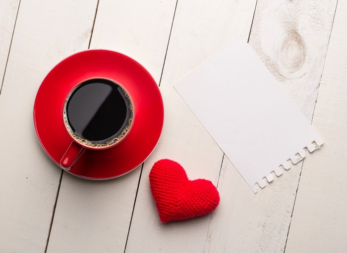 Coffee cup, heart, and blank card on wood planks
