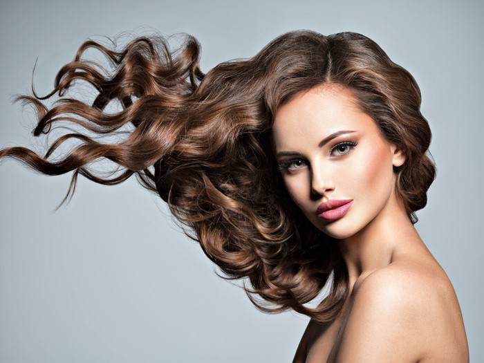 Model with flowing brown hair and makeup