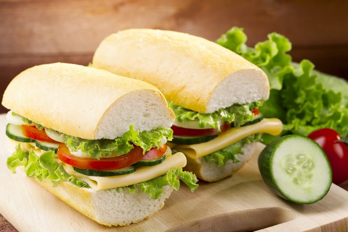 Two sandwiches with vegetables and cheese