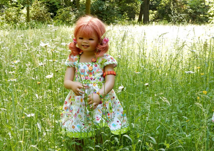 Doll in a dress in a grassy field
