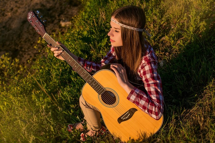 Girl with guitar in grass