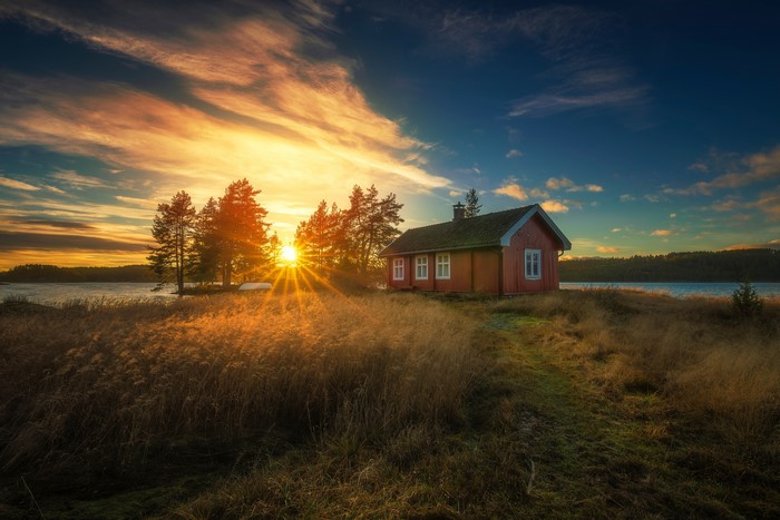 Red house by lake during sunrise in Ringerike, Norway