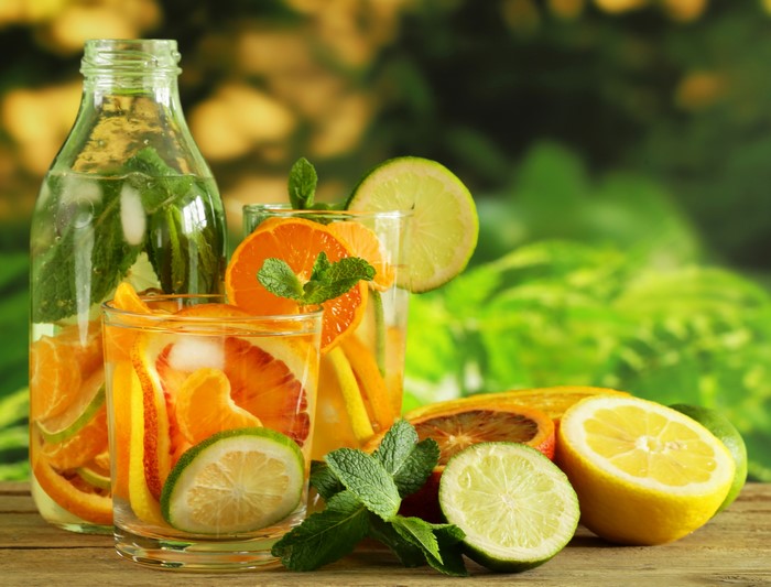 Refreshing citrus and mint infused drinks in glasses and bottle