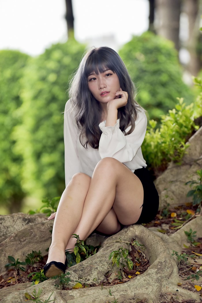 Asian Woman Sitting on Tree Roots