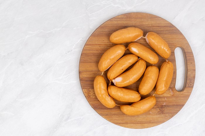 Vienna sausages on a wooden cutting board