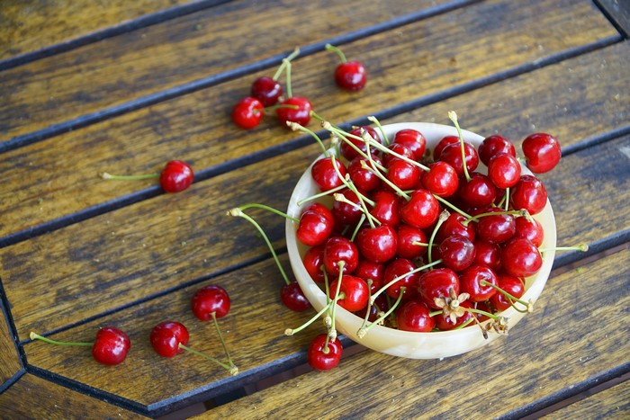 Cherries in a bowl on a wooden table