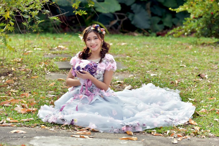 Asian woman in a floral dress holding a bouquet