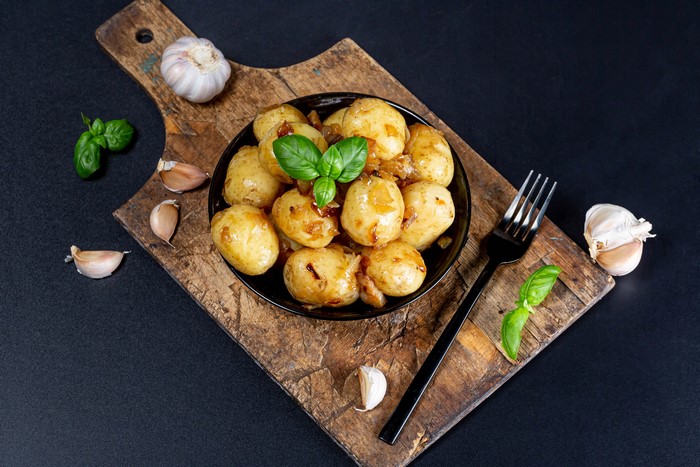 Potatoes with Garlic and Basil on a Cutting Board