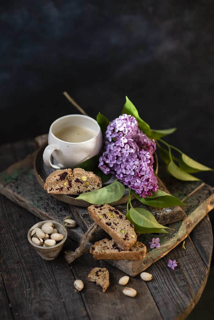 Coffee, Biscotti, Pistachios, and Lilacs on Wood