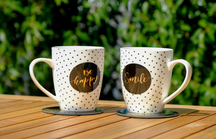 Two mugs with 'Be happy' and 'Smile' text