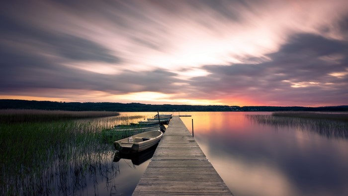 Boats docked at a pier during a sunset in Sweden