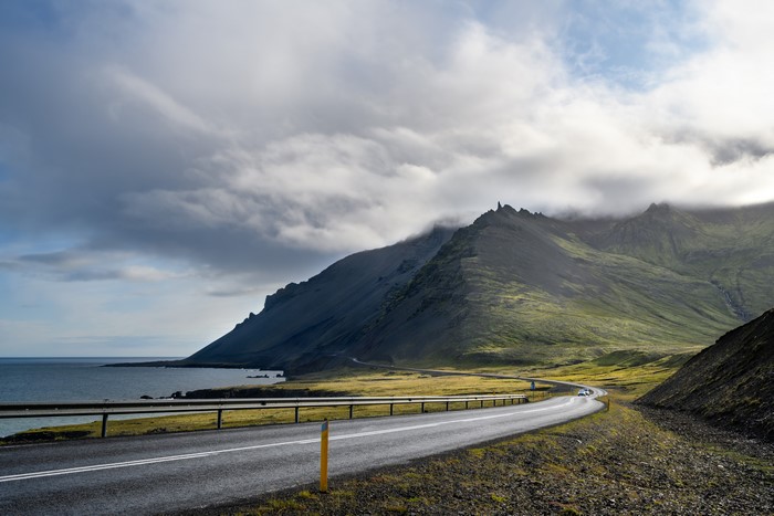 Road along the coast of Iceland with mountains and clouds