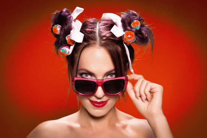 Woman with Chupa Chups in hair wearing sunglasses