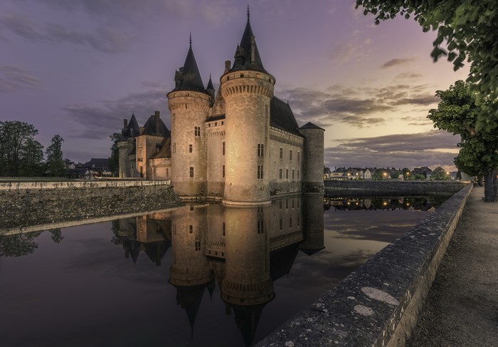 Castle Sully-sur-Loire reflected in moat at dusk