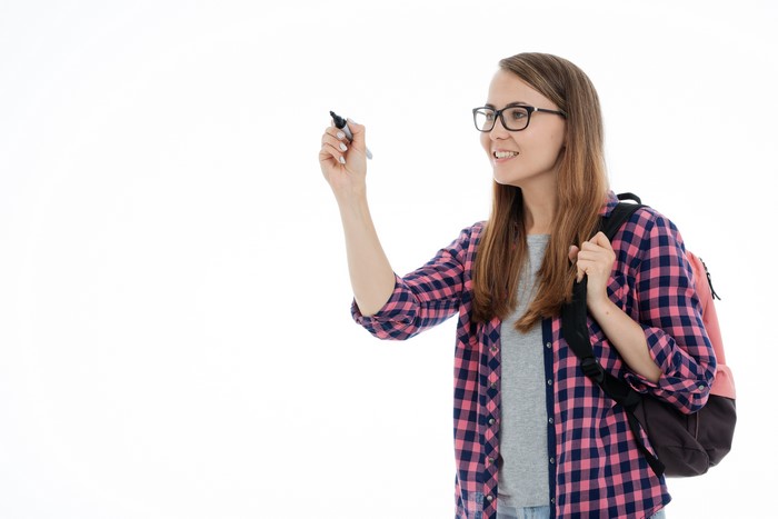 Female student with glasses and backpack writing
