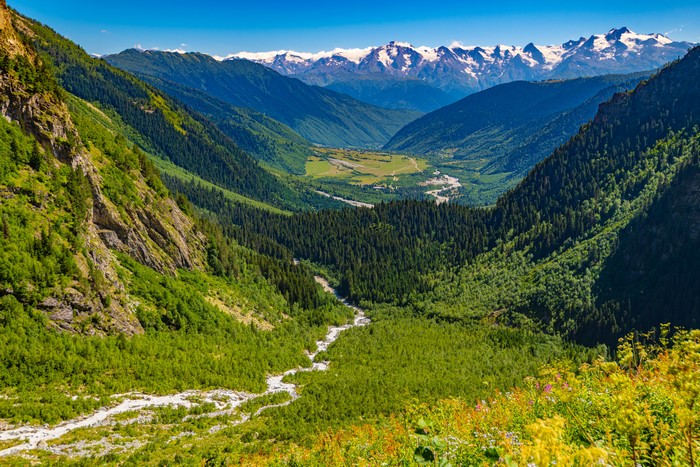 Valley with snow-capped mountains and forests in Georgia