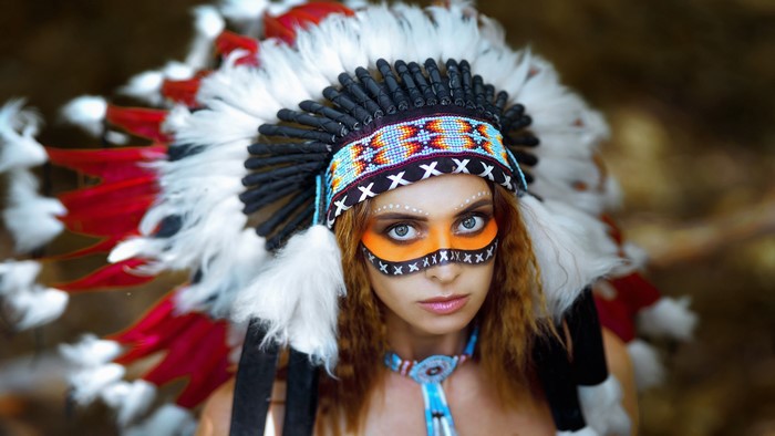 Woman wearing a Native American headdress and face paint