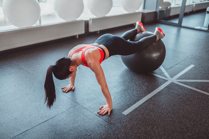 Woman doing push-ups on a fitness ball