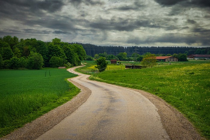 Winding road through Bavarian countryside with farmhouses