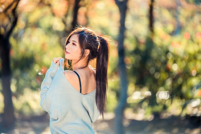 Asian woman with ponytail in a light blue sweater