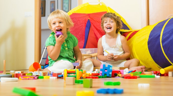 Two happy children playing with toys