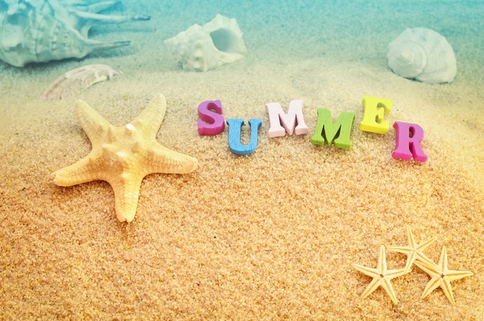 Summer word with starfish and seashells on sand