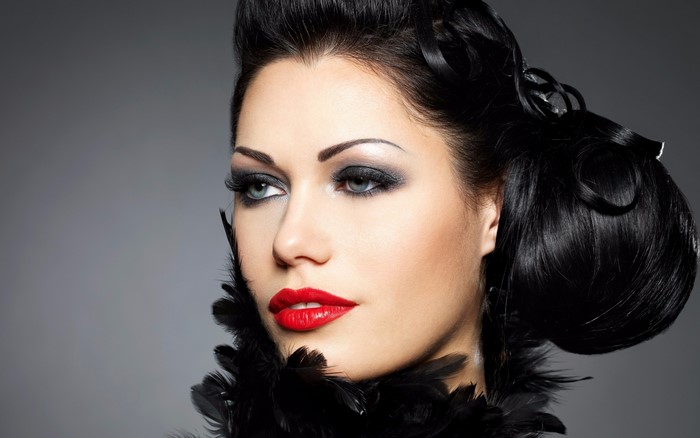 Woman with dramatic makeup and black feathers