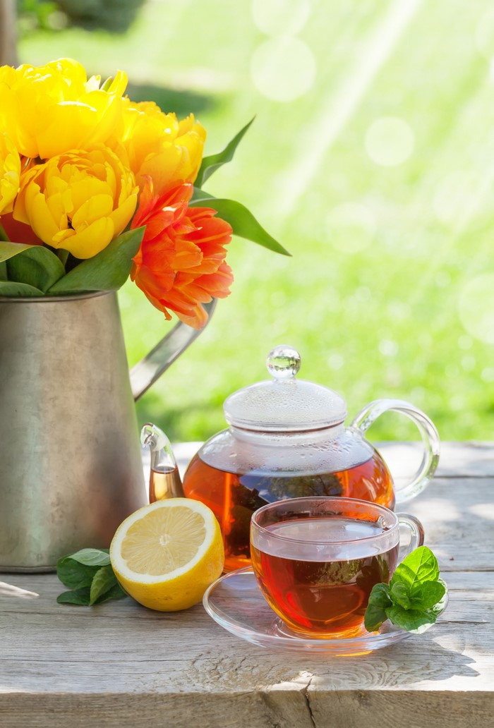 Tea set with tulips and lemon on a wooden table