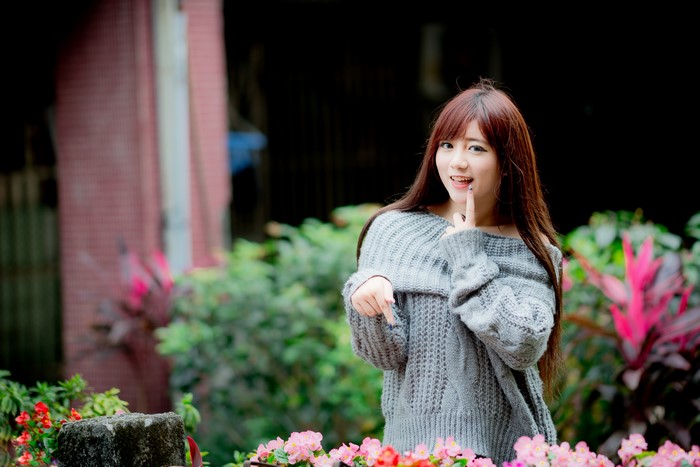 Asian woman with brown hair wearing a grey sweater