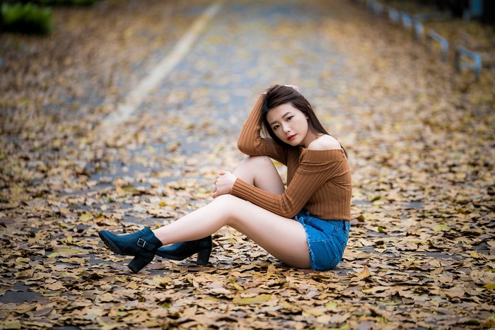 Asian woman sitting on foliage
