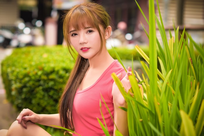 Asian woman with brown hair in a pink shirt