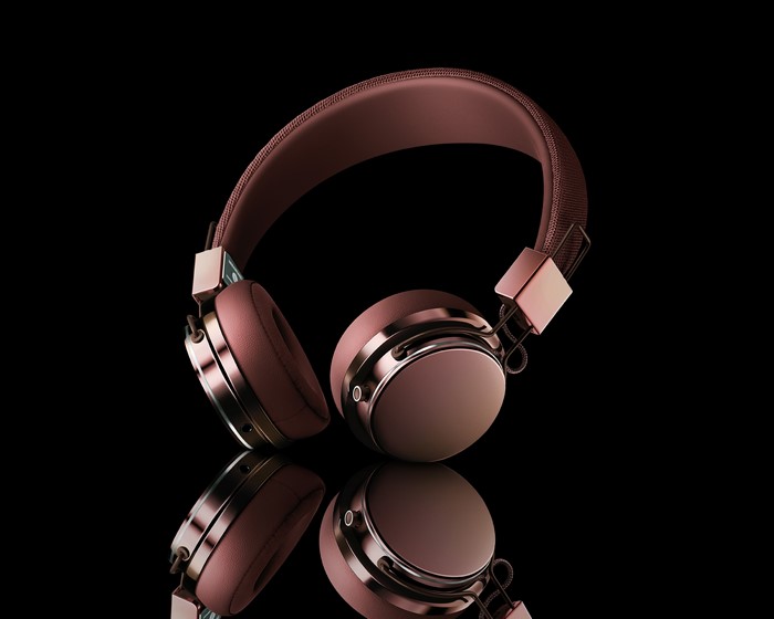 Rose gold headphones with reflection on black background