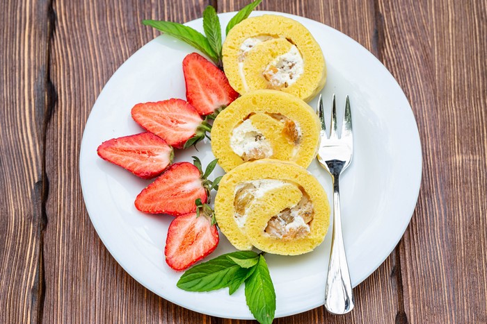 Swiss roll with strawberries on a plate