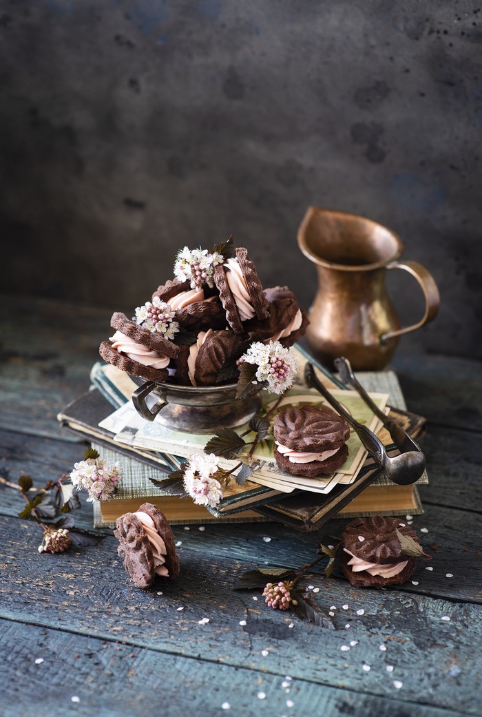 Chocolate sandwich cookies with pink cream and flowers