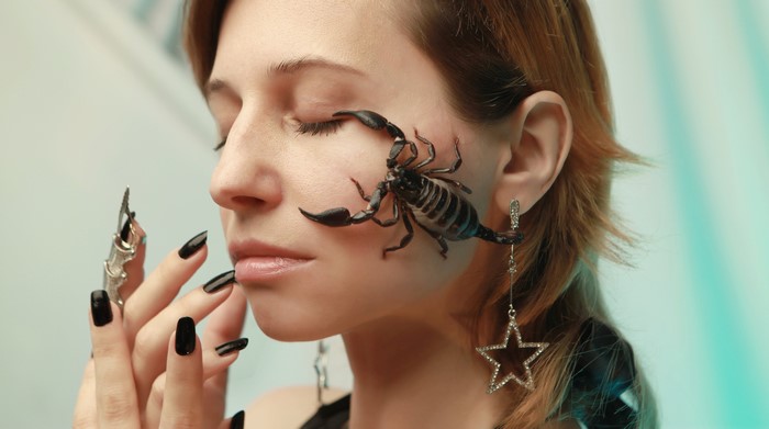 Woman with scorpion on face and star earring