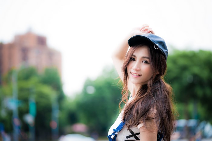 Asian woman with brown hair wearing a baseball cap