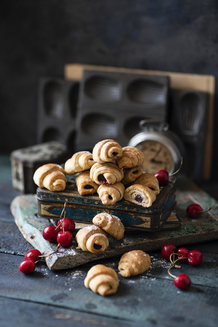 Croissants with cherry filling on a wooden board