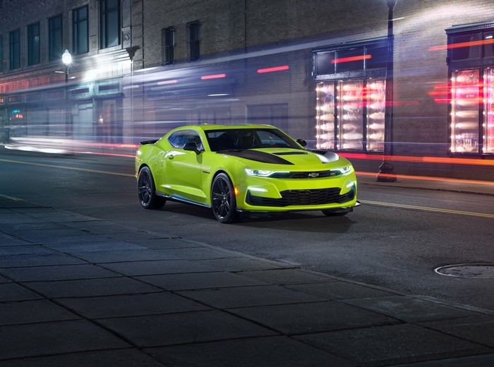 Yellow-green Chevrolet Camaro on a city street at night