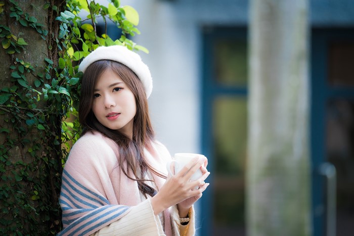 Asian woman in beret holding a mug