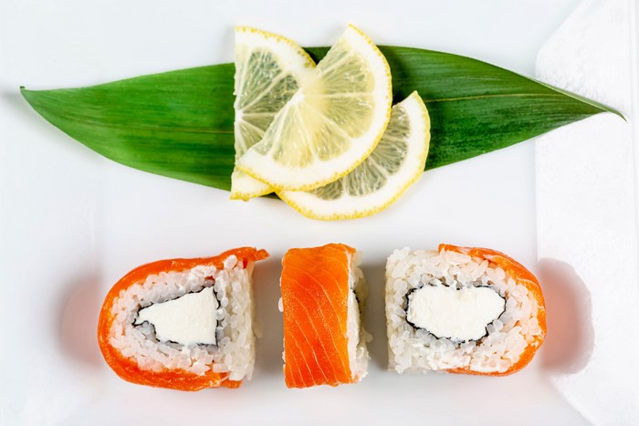 Sushi with Salmon and Cream Cheese, Lemon Slices, and Green Leaf