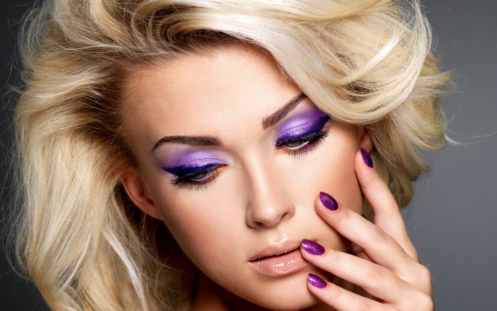 Woman with blonde hair and purple makeup