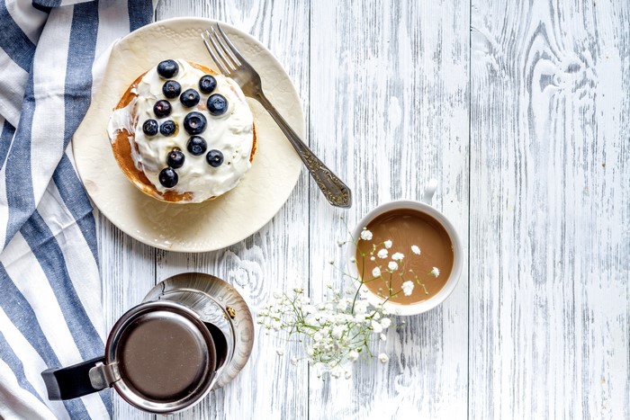 Pancake with blueberries and coffee on a wooden table